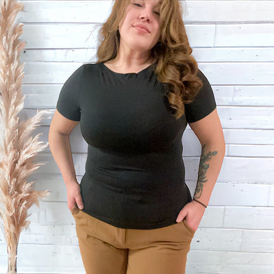 Woman wearing a black comfortable and buttery soft boatneck top with a 3/4 length sleeve 