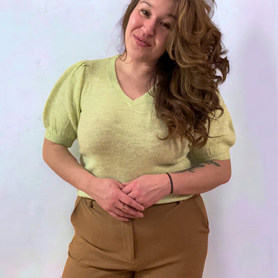 Woman wearing a short puffed sleeve V-neck knit top 
