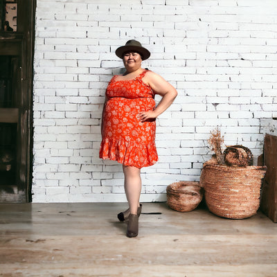 Plus sized woman wearing a comfortable dex smocked summer dress in red orange 