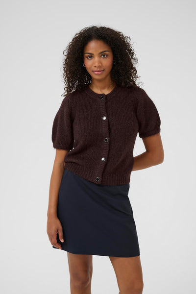 Woman wearing a soft cute and comfortable short sleeve cardigan in the color fudge with black buttons 