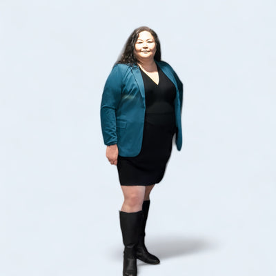 Curvy woman wearing a black sweater dress and teal blazer 