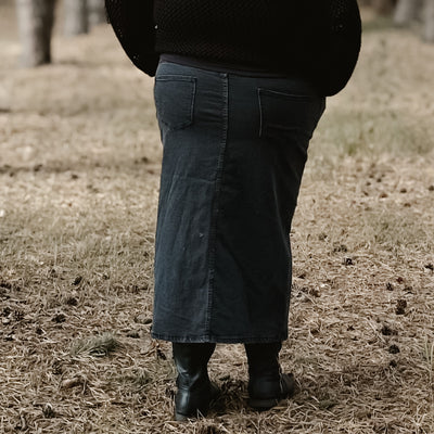 Curvy woman wearing a black denim midi skirt 