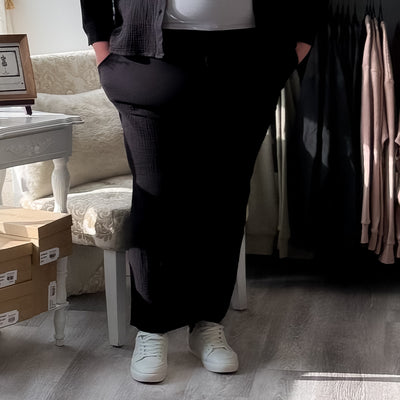 Plus size woman wearing a black textured pull on pant 