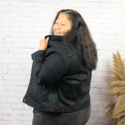 curvy woman wearing a black coated denim jacket 