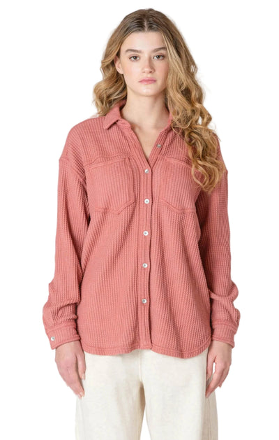 Woman wearing a pink thermal button up shirt jacket from room 34
