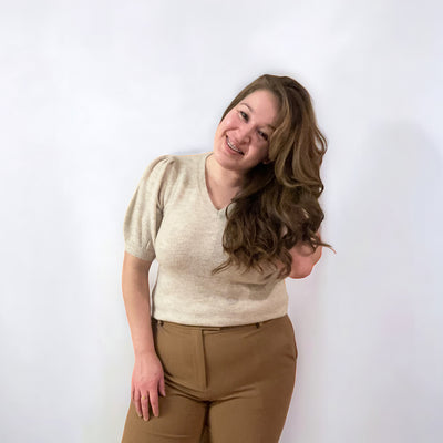 Woman wearing a soft V-neck short puffed sleeve sweater in the color birch 