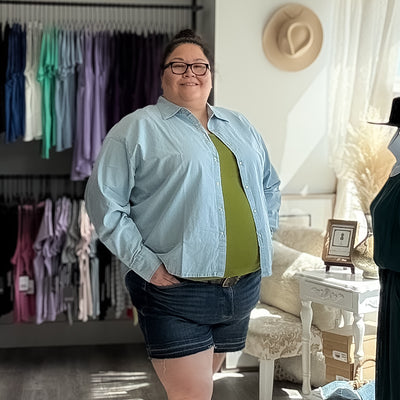 Plus Size Woman wearing a cute and comfortable chambray long sleeved button up as a layering piece for a sprung outfit 