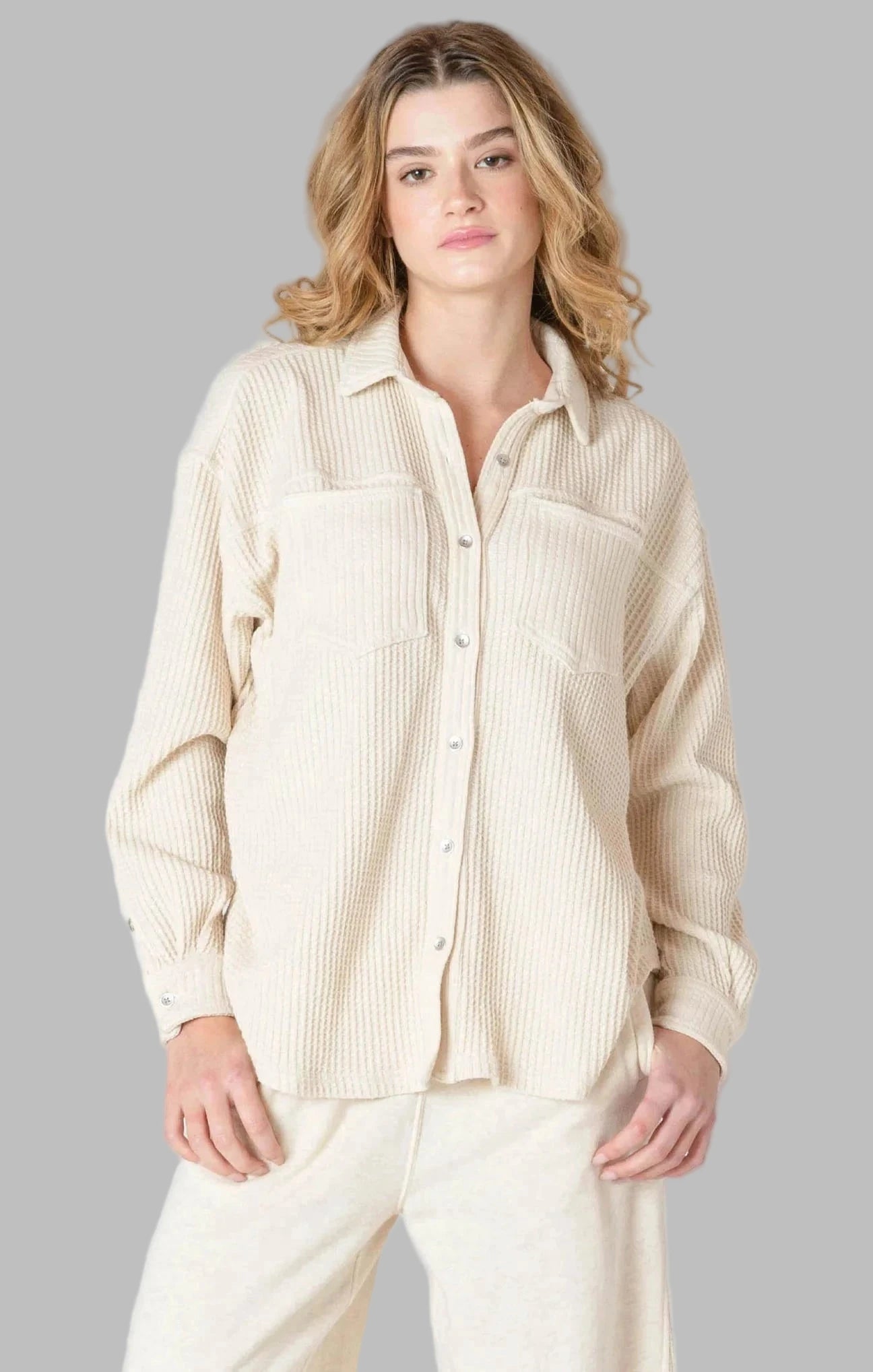 Woman wearing a beige thermal knit button-up shirt and pants by room 34