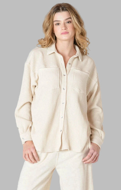 Woman wearing a beige thermal knit button-up shirt and pants by room 34