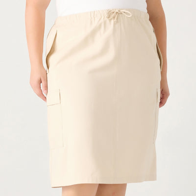 Curvy woman wearing a cream coloured midi length cargo skirt with a drawstring waist and a back slit. 