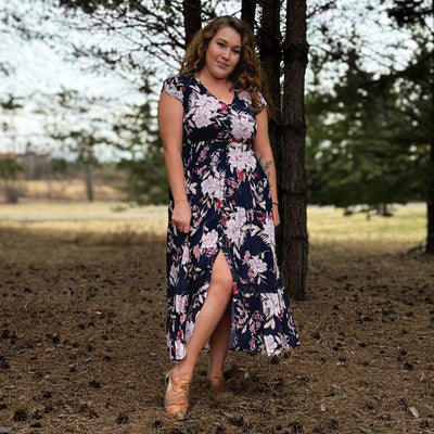 Woman wearing a floral tiered maxi dress with button up front and flutter sleeves 