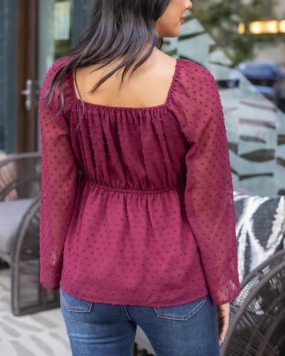 Burgundy flowy top with long sleeves and elastic neckline 