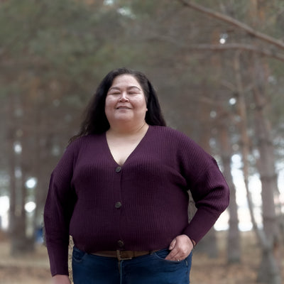 Plus sized woman wearing a plum coloured knit cardigan 