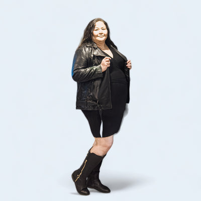 Curvy sized woman wearing a sweater dress and vegan leather Moto jacket 