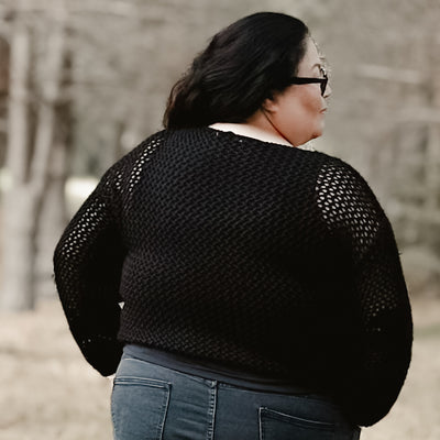 Plus size woman wearing an open knit crochet sweater 