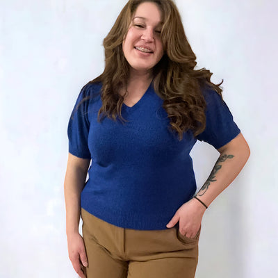 Curvy woman wearing a blue short sleeved V-neck knit sweater
