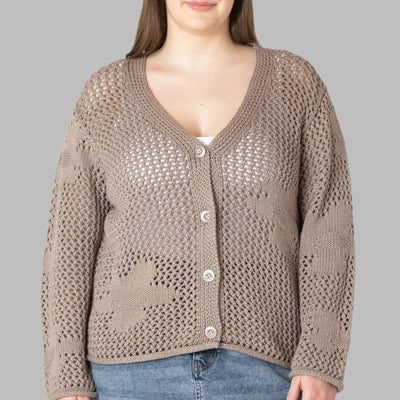 plus size woman wearing a cute and comfortable light beige crochet long sleeved cardigan featuring a floral design and front button closure